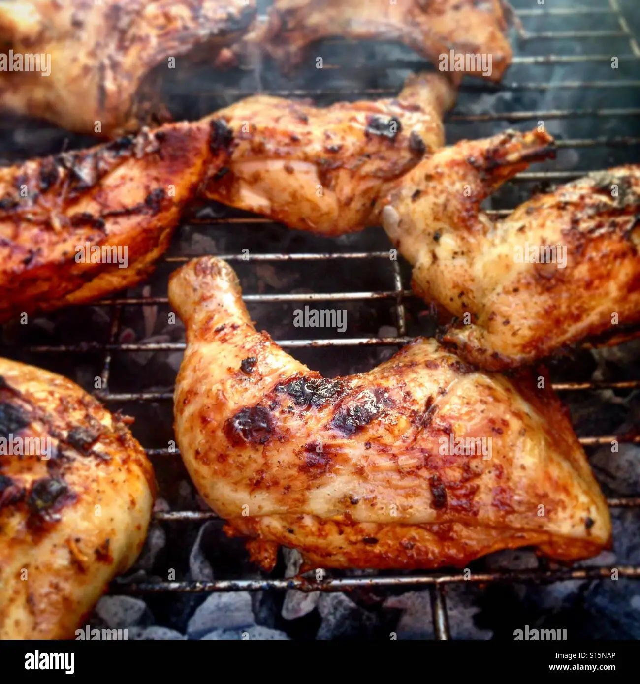 Closeup of making BBQ chicken on a charcoal grill Stock Photo