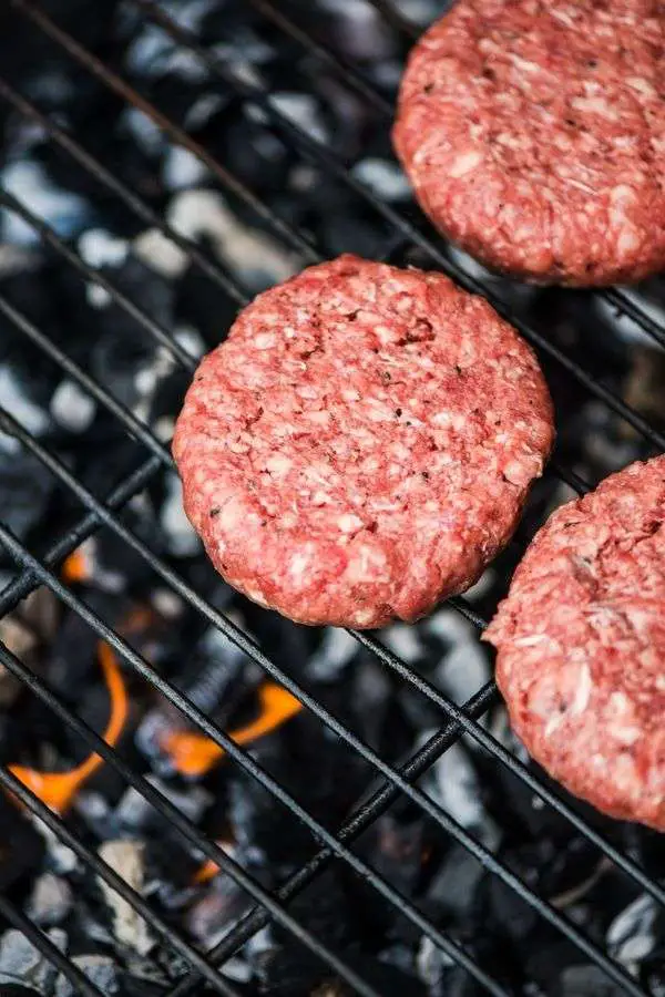ground beef burger patties on grill uncooked